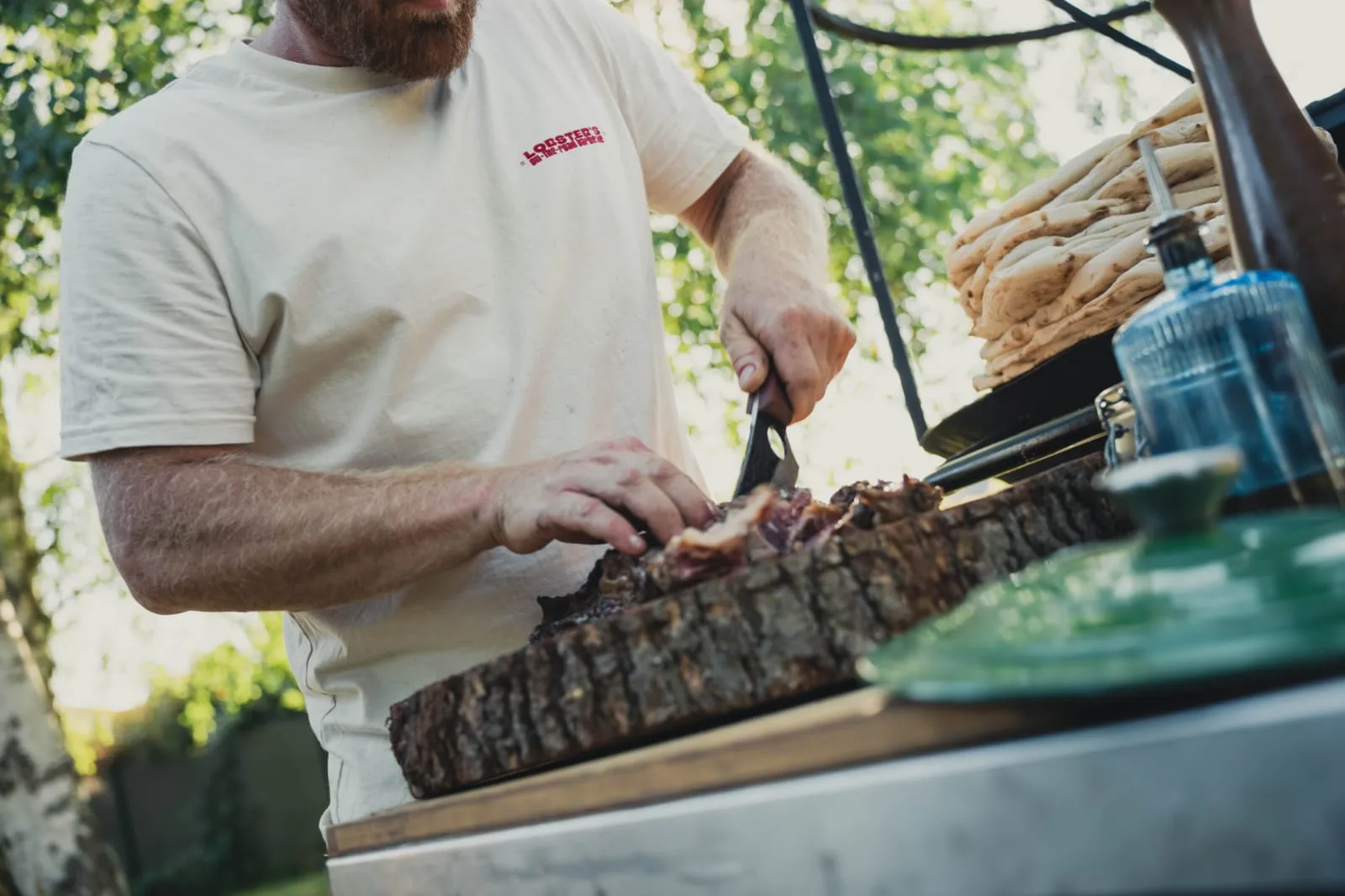 Camille Robadey tranche une côte de bœuf au brasero devant les invités